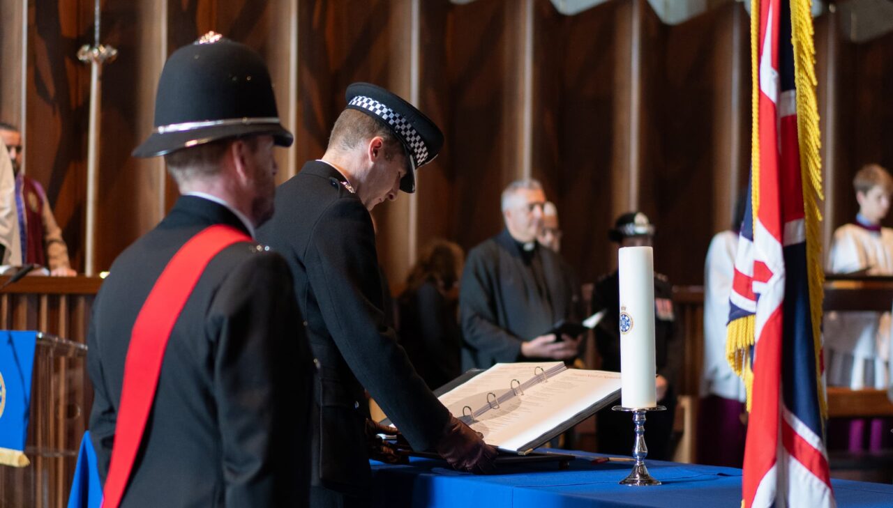 Two officers standing in front of the Police Remembrance Trust book
